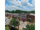 Aerial view showcasing a charming town square with shops, cars, and lush trees at 10 James St # 11B, Hampton, GA 30228