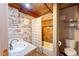 Cozy bathroom with exposed brick, single sink vanity and shower/tub featuring decorative tile at 10 James St # 11B, Hampton, GA 30228
