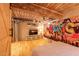 Charming bedroom features exposed wood beams, ductwork, hardwood floors, and a colorful mural wall at 10 James St # 11B, Hampton, GA 30228