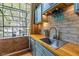 Modern kitchen sink with butcher block countertops, brick backsplash, and wine glass rack at 10 James St # 11B, Hampton, GA 30228