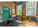 Open living area with exposed brick, large windows, eclectic door art, and modern furniture at 10 James St # 11B, Hampton, GA 30228