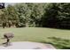 Spacious backyard with mature trees, level lawn, and patio with grill perfect for outdoor entertaining at 180 Jay Trl, Fayetteville, GA 30215