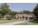 Beautiful brick home with a lush green lawn and mature trees surrounding the property at 180 Jay Trl, Fayetteville, GA 30215