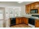 Eat-in kitchen features wood cabinets, granite countertops, and modern black appliances at 180 Jay Trl, Fayetteville, GA 30215