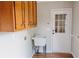 Laundry room with wood cabinets, utility sink, and door to the exterior at 180 Jay Trl, Fayetteville, GA 30215