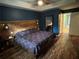 Bedroom featuring a wood accent wall with lighting, drawers under bed and beautiful flooring at 2105 Windy Oak Ct, Lithia Springs, GA 30122
