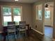 Bright dining area featuring dark wood floors, a rustic table, and large windows overlooking the yard at 2105 Windy Oak Ct, Lithia Springs, GA 30122