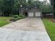 Home showcasing a long driveway leading to a two-car garage, complemented by a spacious front yard at 2105 Windy Oak Ct, Lithia Springs, GA 30122