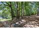 Secluded backyard area featuring mature trees, natural shade and stone features at 2709 Gentry Dr, Douglasville, GA 30135