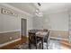 Inviting dining room features classic decor, wainscoting, wood floors, and a modern chandelier at 2709 Gentry Dr, Douglasville, GA 30135