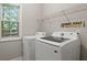 Functional laundry room with modern washer and dryer, natural light, and storage shelving at 2709 Gentry Dr, Douglasville, GA 30135