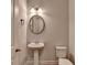 Powder room featuring pedestal sink, oval mirror, and a neutral color palette at 3695 Andover St, Cumming, GA 30028