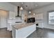 Kitchen boasts a large island, quartz countertops, stainless steel appliances, and white cabinetry at 3695 Andover St, Cumming, GA 30028