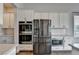 Kitchen featuring stainless steel appliances, built-in microwave, oven, and white cabinetry at 3695 Andover St, Cumming, GA 30028