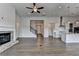 Open-concept living room with a brick fireplace, kitchen island, and hardwood flooring at 3695 Andover St, Cumming, GA 30028