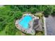 Aerial view of an irregular shaped community pool surrounded by chairs, umbrellas, and lush landscaping at 3695 Andover St, Cumming, GA 30028