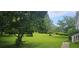 Expansive green front yard featuring mature trees and a neatly maintained lawn area at 4055 Haralson Mill Ne Rd, Conyers, GA 30012