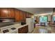 Functional kitchen featuring wooden cabinets, white appliances, and view into the dining area at 4055 Haralson Mill Ne Rd, Conyers, GA 30012