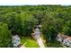 Aerial shot showcasing this charming home with a long driveway amidst lush trees and a sprawling lawn at 169 Knights Ct, Dallas, GA 30157