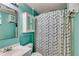 Bathroom featuring light blue paint, a tub with geometric curtains, and a medicine cabinet at 169 Knights Ct, Dallas, GA 30157