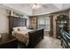A bedroom with a tray ceiling, dark wood furniture, and a large window at 169 Knights Ct, Dallas, GA 30157