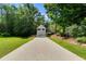 Charming two-story home featuring a long concrete driveway and lush surrounding foliage at 169 Knights Ct, Dallas, GA 30157