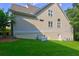 Exterior of home featuring lush green lawn, mature trees, and beige siding at 490 Grand Teton Cir, Fayetteville, GA 30215