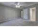 Bedroom with gray walls, plush carpeting, a ceiling fan, and two closets, one leading to the bathroom at 490 Grand Teton Cir, Fayetteville, GA 30215