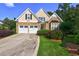 Charming home featuring a two-car garage, stone accents, and manicured landscaping at 490 Grand Teton Cir, Fayetteville, GA 30215
