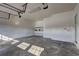 Spacious garage with white walls, concrete floors, overhead lighting, and built-in shelving at 490 Grand Teton Cir, Fayetteville, GA 30215