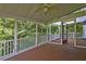Screened-in porch with wood flooring, white railings, and a view of the lush green surroundings at 490 Grand Teton Cir, Fayetteville, GA 30215