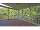 Screened porch with ceiling fan, railing, and wood flooring overlooking trees in the backyard at 490 Grand Teton Cir, Fayetteville, GA 30215