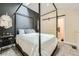 Primary bedroom with a four-poster bed, dark accent wall, gray carpet and barn door to an ensuite bath at 799 Hammond Dr # 427, Atlanta, GA 30328
