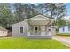 Charming single-story home with a covered front porch and manicured green lawn at 1441 Monteel Nw Dr, Atlanta, GA 30318