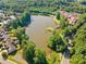 Aerial view showcases community pond surrounded by mature trees and upscale homes at 137 Hidden Lake Cir, Canton, GA 30114