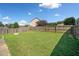 Spacious backyard with green grass, a stone fire pit, and a wood fence at 137 Hidden Lake Cir, Canton, GA 30114