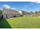 Wide backyard with green grass, a wood fence, and a stone fire pit at 137 Hidden Lake Cir, Canton, GA 30114