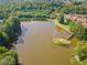 Aerial shot of a serene pond featuring an island with bridge, surrounded by lush greenery and trees at 137 Hidden Lake Cir, Canton, GA 30114