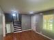 Spacious living room with hardwood floors, staircase access, and a large window overlooking the yard at 273 Fennel Way, Atlanta, GA 30331