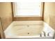 A relaxing soaking tub by a window and tile accents in the bathroom at 1109 Norsworthy Ml, Hampton, GA 30228