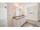 Bathroom featuring double sinks, a large mirror, and a separate tub at 1936 Waycross Ln, Dacula, GA 30019