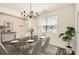 Elegant dining room with modern lighting, table set, and large window at 1936 Waycross Ln, Dacula, GA 30019