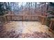 Outdoor deck with wooden railing overlooking the backyard with trees, and fallen leaves at 6674 Mimosa Cir, Tucker, GA 30084