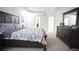 Well-lit main bedroom with a large bed, dresser, and neutral carpeting at 6674 Mimosa Cir, Tucker, GA 30084