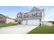 Charming two-story home featuring a gray exterior, manicured lawn and two-car garage at 1049 Bodega Loop, Locust Grove, GA 30248