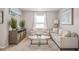 Cozy living room with loveseat, sofa, decorative plants, and large window at 1049 Bodega Loop, Locust Grove, GA 30248