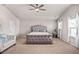 Spacious main bedroom featuring a king bed, ceiling fan, and sitting area at 1049 Bodega Loop, Locust Grove, GA 30248