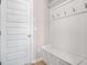 Mudroom area with a built in bench and coat hooks, by a white door at 1049 Bodega Loop, Locust Grove, GA 30248