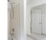 Bathroom tub shower combo showcasing white tiling, tiled floors, and bright vanity lighting at 1051 Rock Springs Rd, Lawrenceville, GA 30043