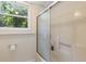 Bathroom with a shower showcasing sliding glass doors and natural light from a nearby window at 1051 Rock Springs Rd, Lawrenceville, GA 30043